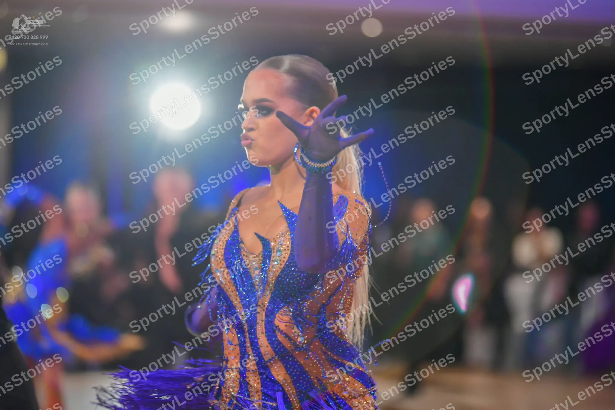 Dancesport competitor: Female dancer: blue and gold sequined Latin dance dress with long blue gloves