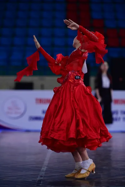 Dancesport competitor: ** Female: Red latin dress with fringe
