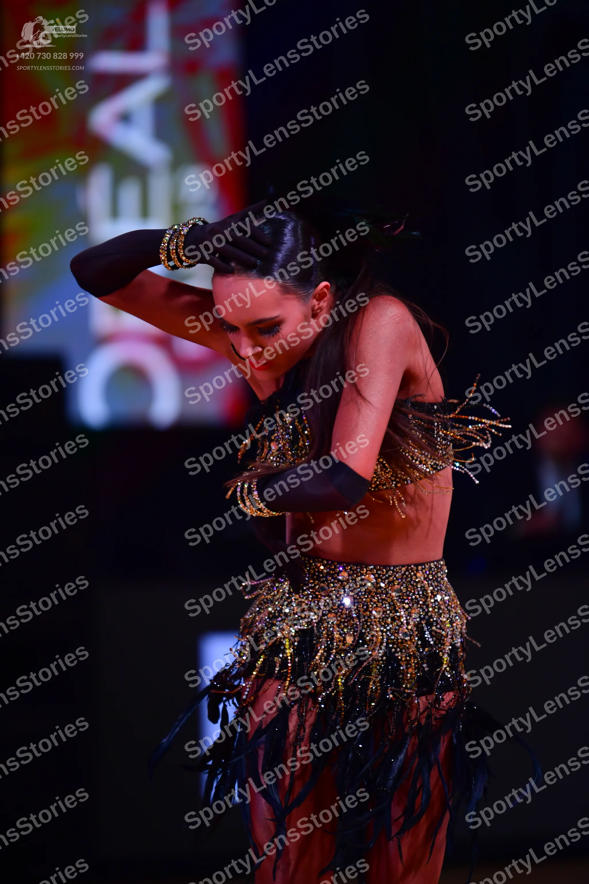 Dancesport competitor: Female dancer: black and gold latin costume with sequin/beaded patterns and long