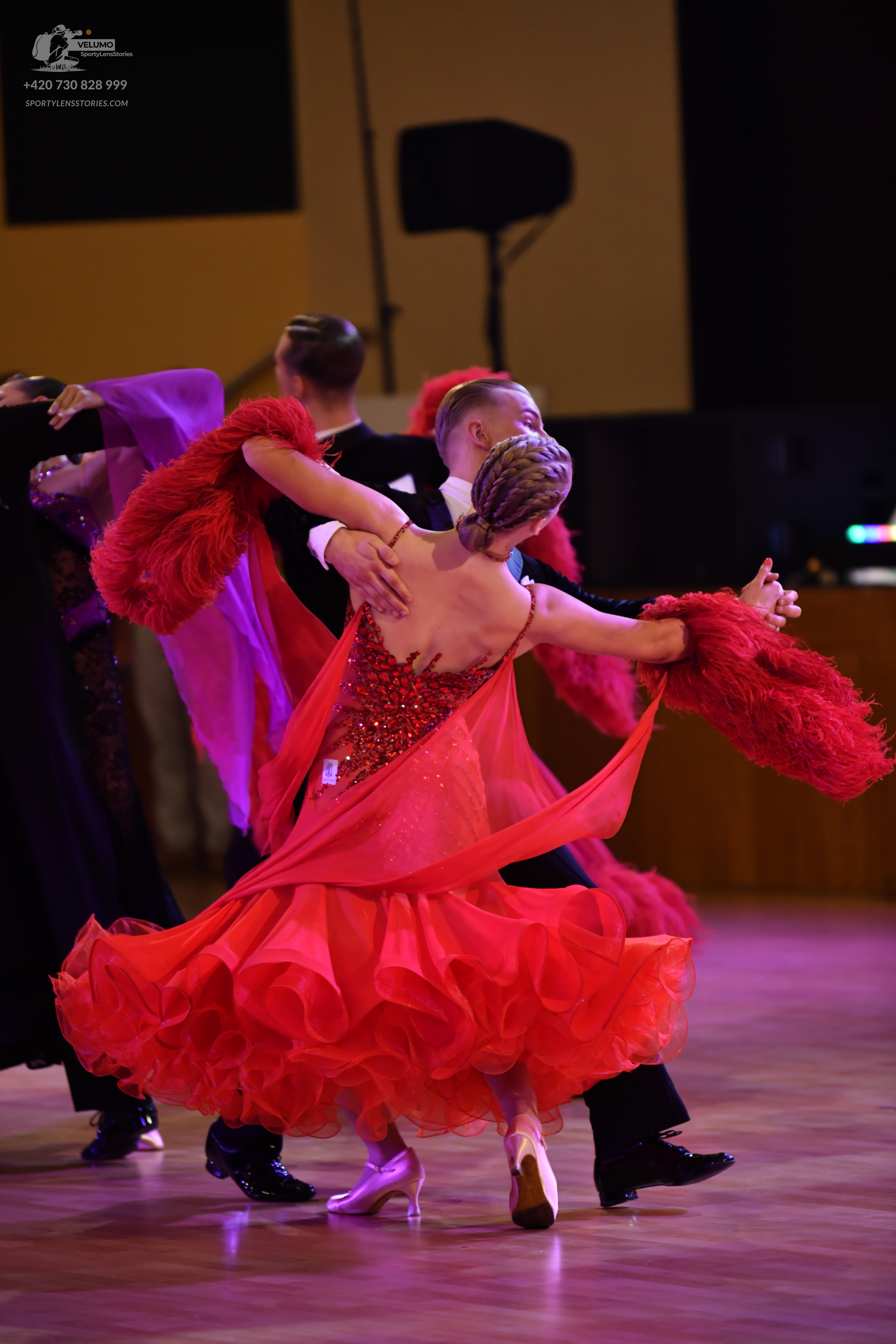 Dancesport competitor: Female dancer: red Latin dress with a sequined bodice and a voluminous, multi-la
