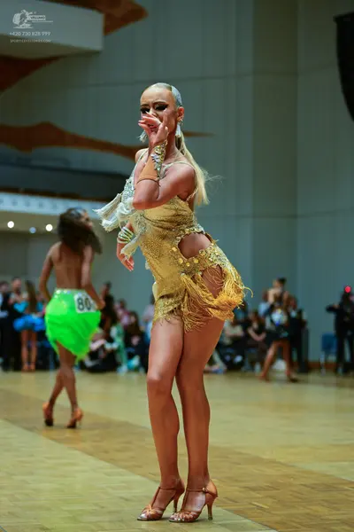 Dancesport competitor #86: Female dancer (foreground): gold latin dress with sequins and fringe