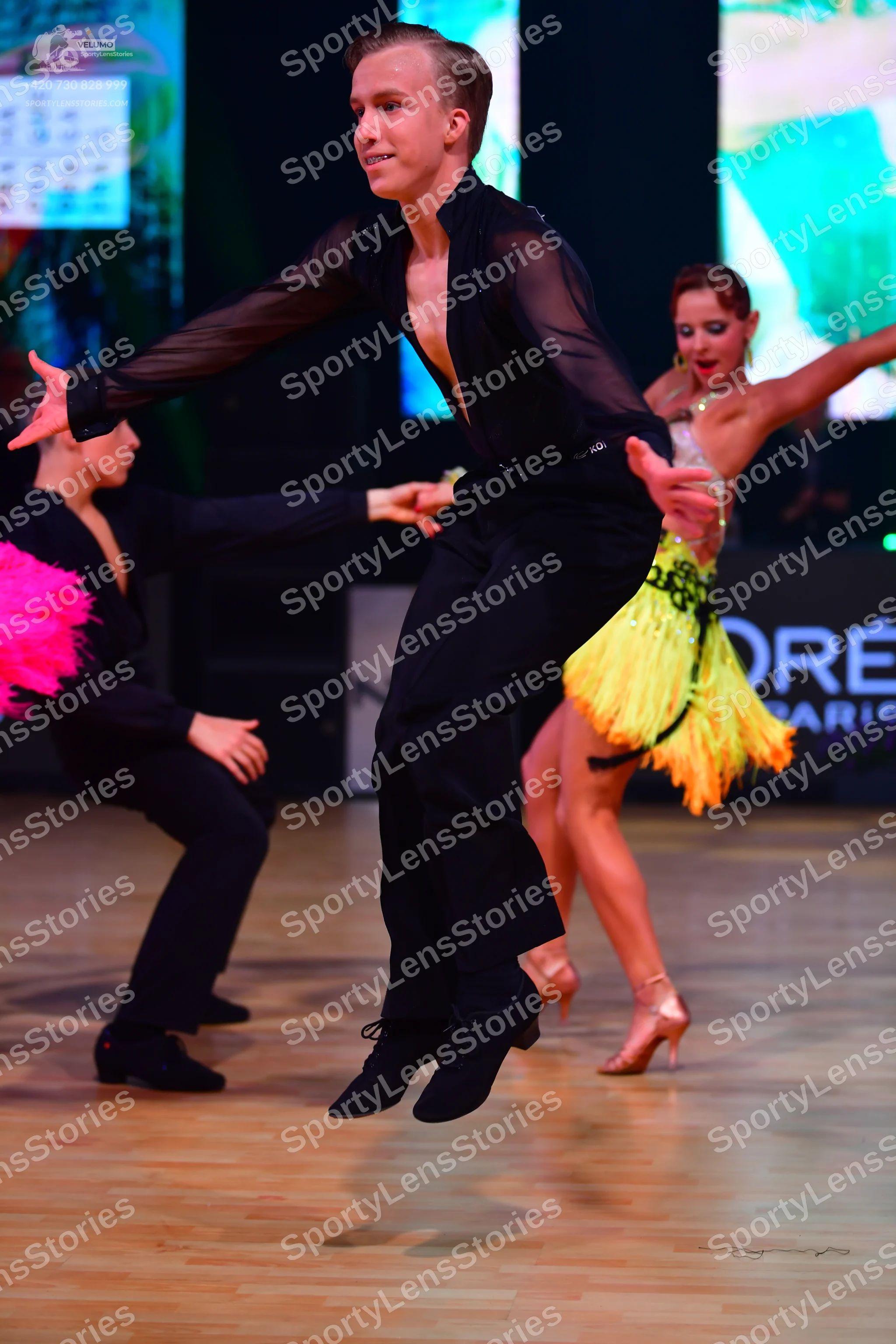 Dancesport competitor: Male dancer: black sheer long-sleeved shirt and black trousers