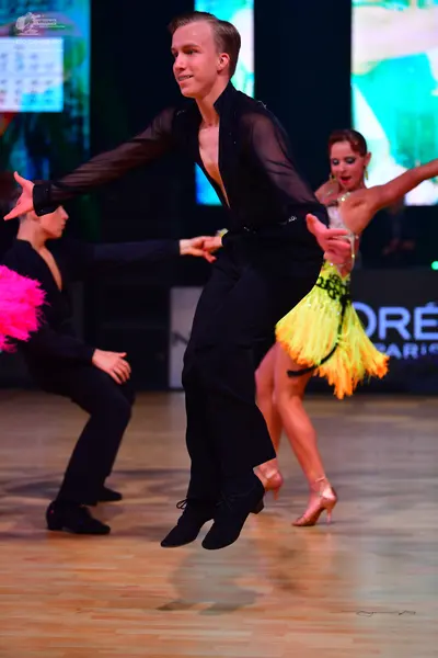 Dancesport competitor: Male dancer: black sheer long-sleeved shirt and black trousers