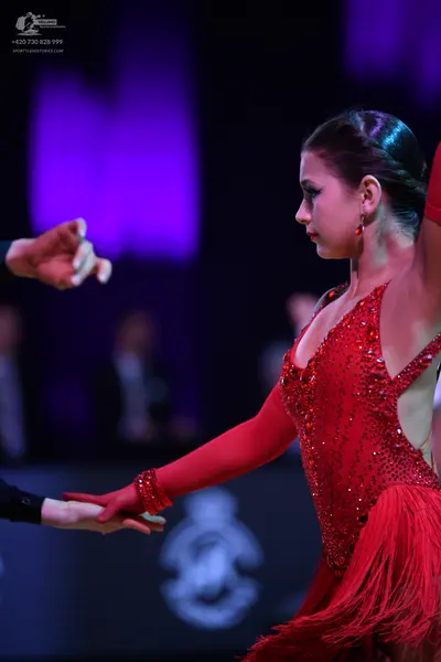 Dancesport competitor: Female dancer: red latin dress with sequins, long sleeves, and fringe