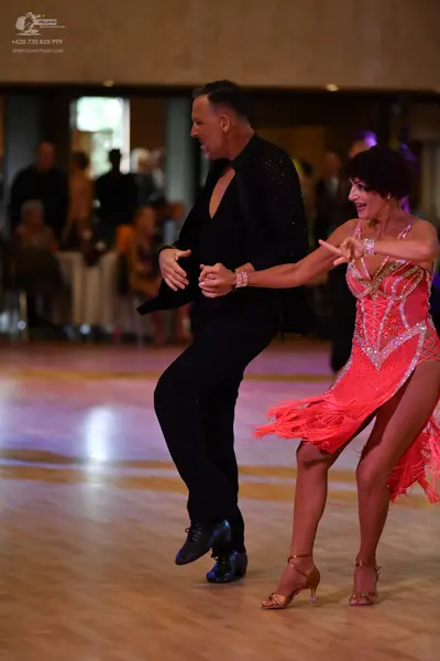Dancesport competitor: Male:** Black tailored suit with sequins along the lapels and cuffs