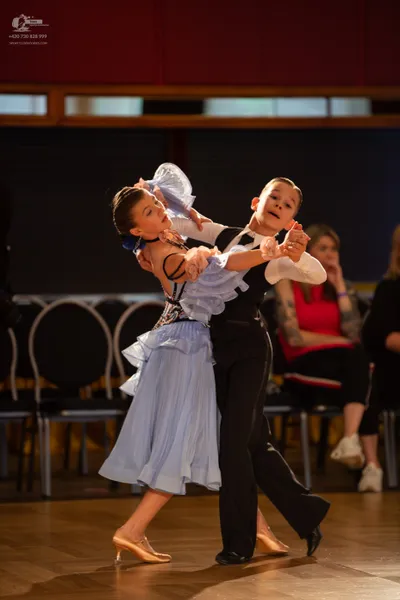 Dancesport competitor: Male dancer: black waistcoat, white long-sleeved shirt, and black trousers