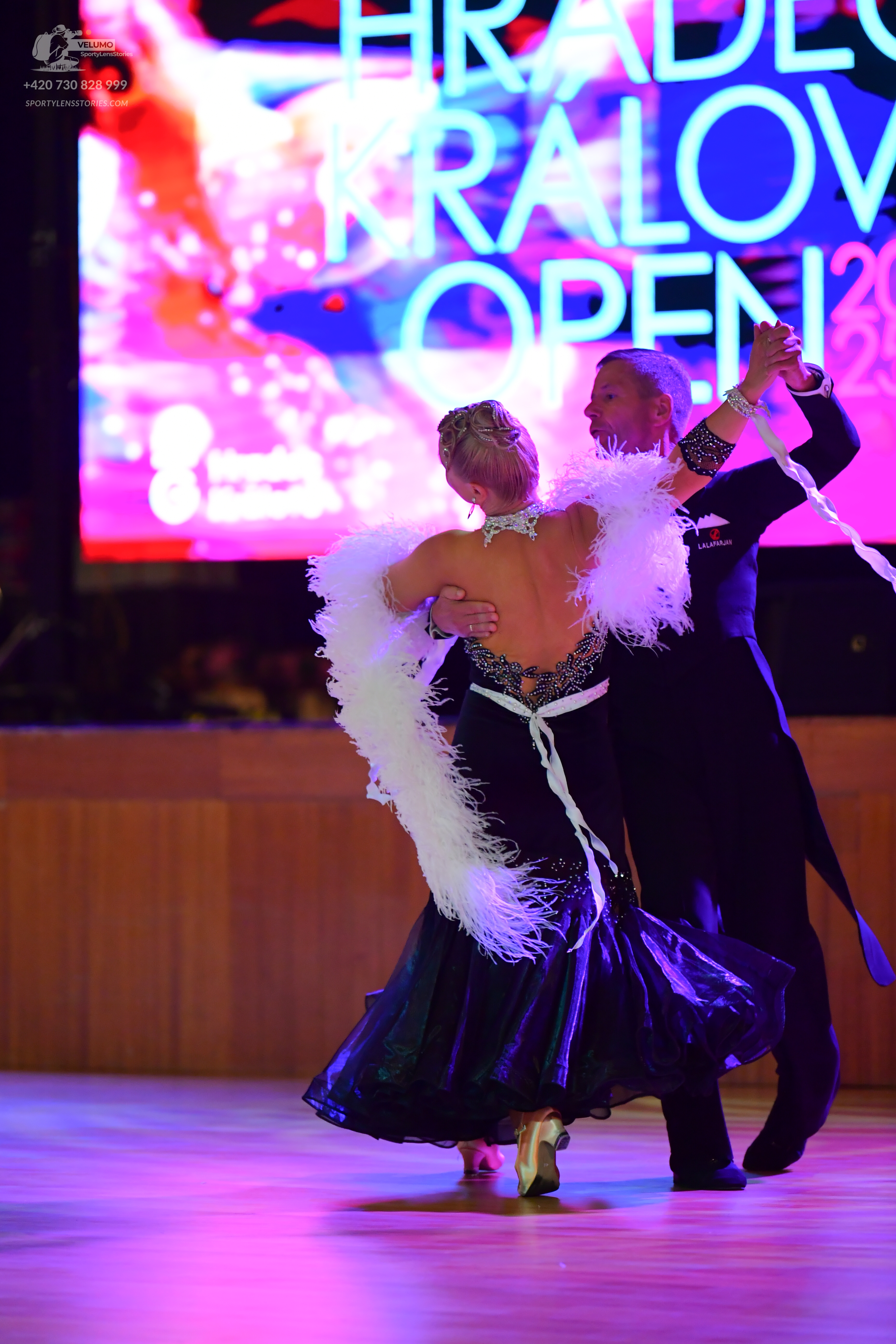Dancesport competitor: Male:** Black suit with a long, dramatic train and sequins on the lapels