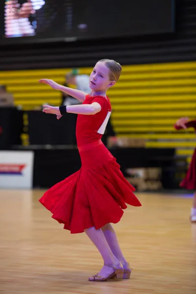 Dancesport competitor: ** Female: Red latin dress with lace detailing, with a flared skirt and a scallo
