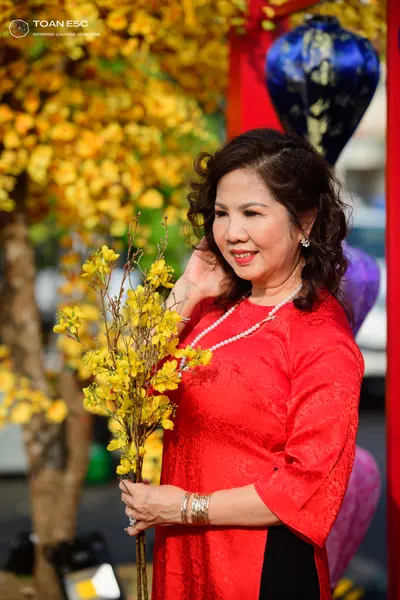 Dancesport competitor: Female dancer: red patterned top with a white pearl necklace and silver bracelet