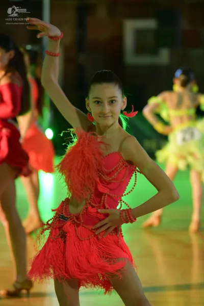 Dancesport competitor #27: Female dancer in foreground: pink Latin dress with long fringe and bead strands,