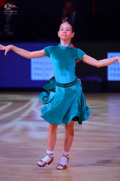 Dancesport competitor: Female dancer: teal satin-like dress with short sleeves, a high neckline, and a 