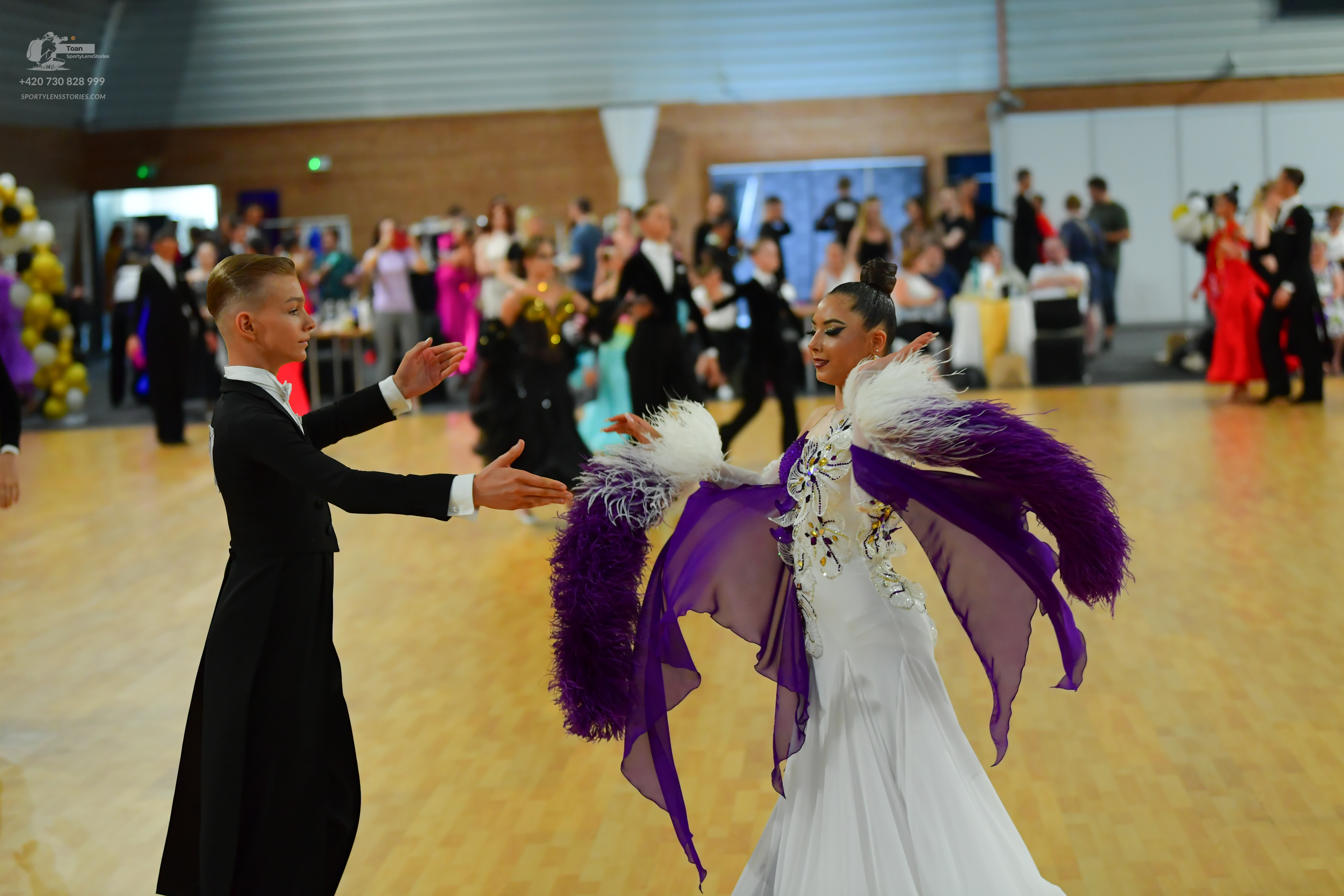 Dancesport competitor: Male (Left):** Black tail suit with silver/white sequin lapels