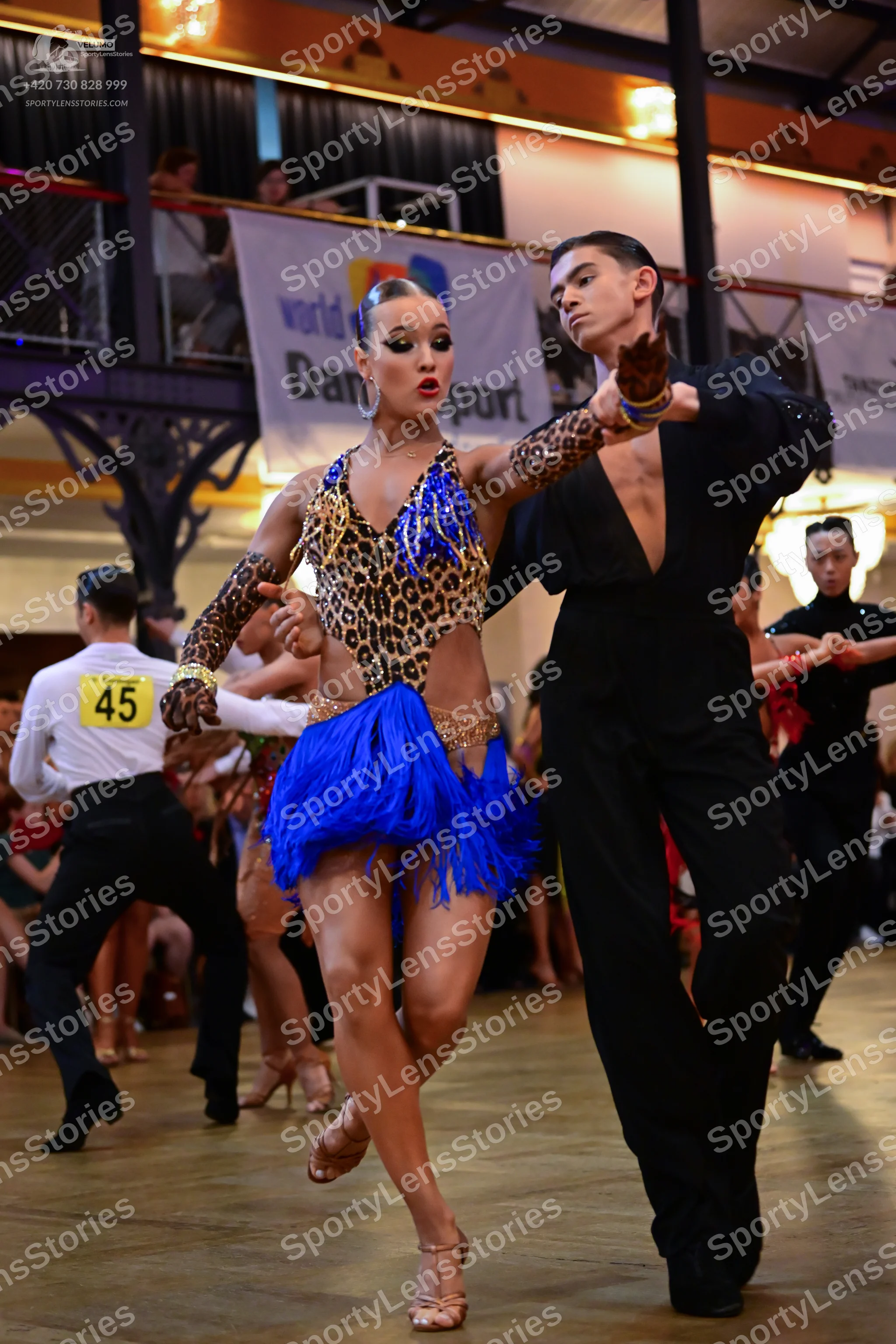 Dancesport competitor #45: Female dancer: leopard print Latin dress with bright blue fringe skirt and blue/