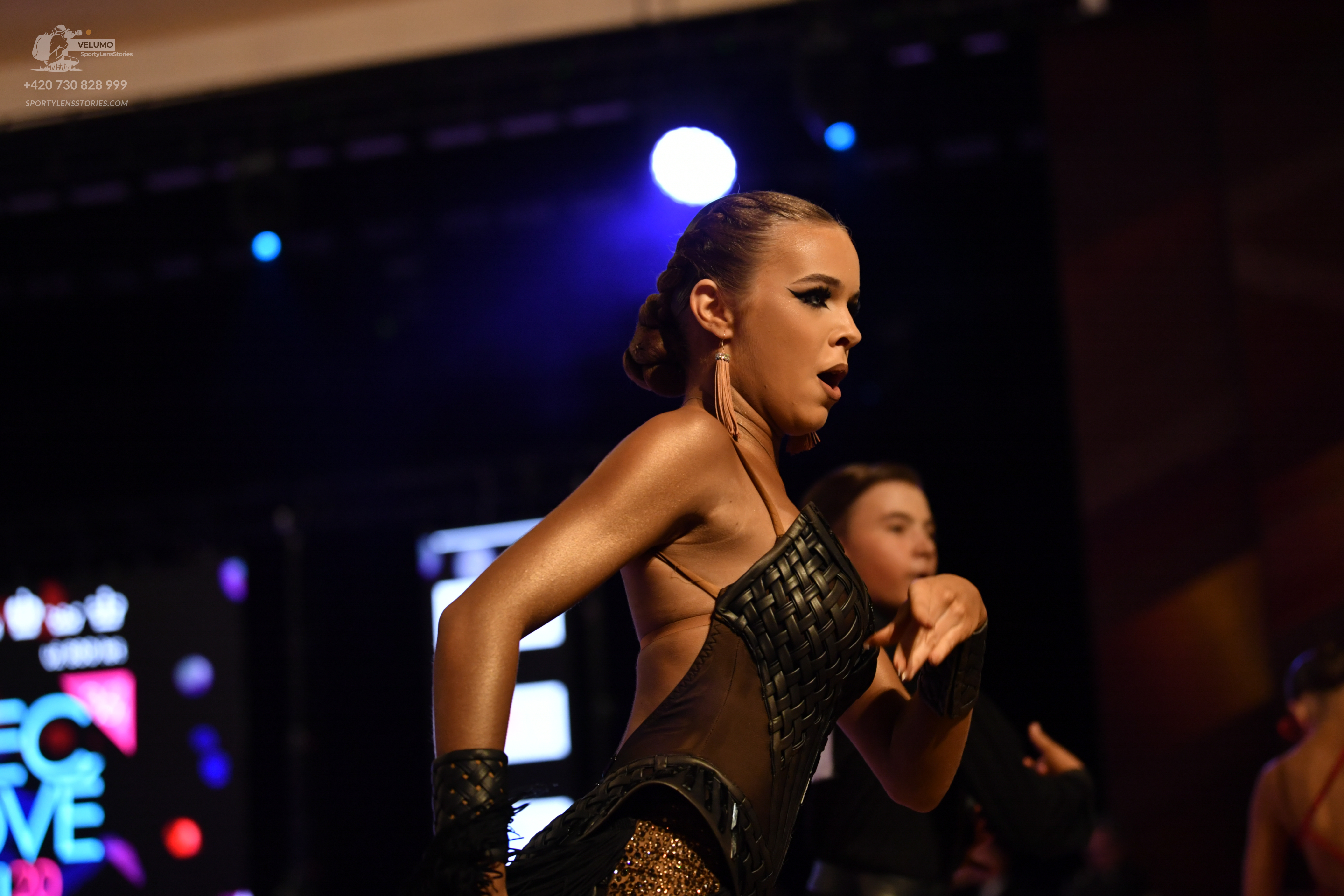 Dancesport competitor: ** Black, form-fitting latin dress
*   **Fabric:** Primarily a shiny, textured f