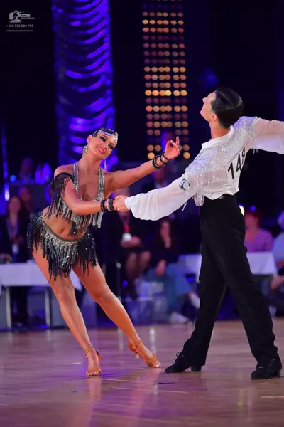 Dancesport competitor #149: Female dancer: black latin costume with silver sequins and long metallic fringe,