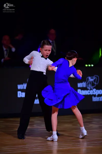Dancesport competitor: Male dancer: white long-sleeved shirt, black trousers, and a black bowtie