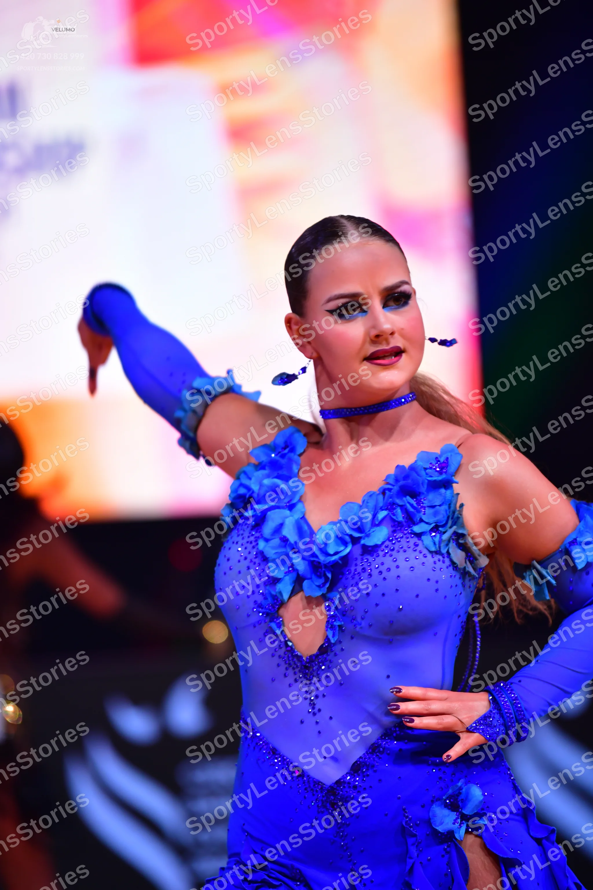 Dancesport competitor: Female dancer: bright blue Latin dance dress with 3D floral appliqués, rhineston
