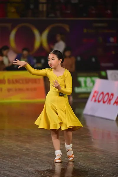 Dancesport competitor: Female dancer: yellow long-sleeved dress with a flared skirt