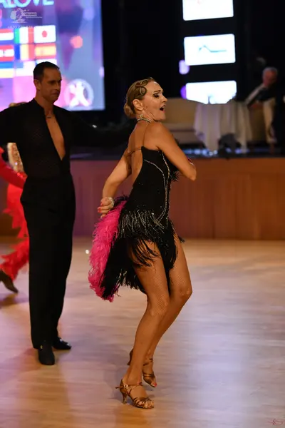 Dancesport competitor: Male dancer: black long-sleeved shirt with a deep V-neck and black trousers