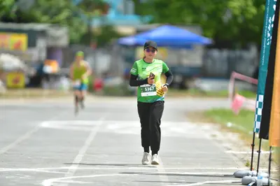Marathon runner #5367: Runner 1: green jersey, black long sleeves, black pants, white shoes, black cap,