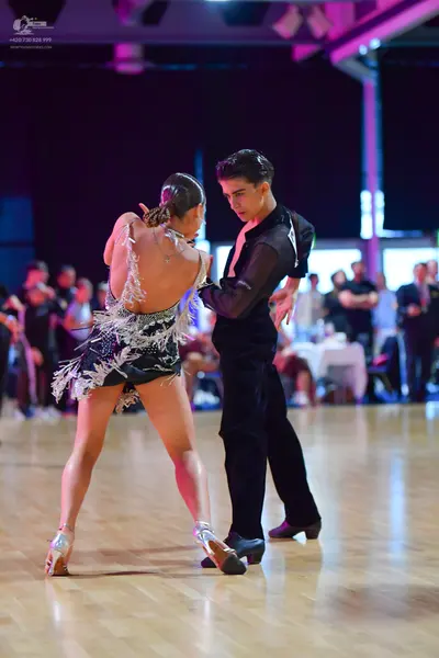 Dancesport competitor: Male dancer: black long-sleeved shirt with white detailing on the shoulder and b
