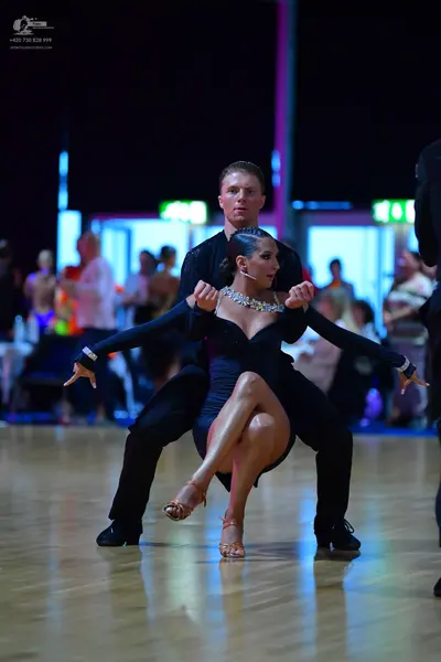 Dancesport competitor: Male dancer: black dance trousers and a black long-sleeved top