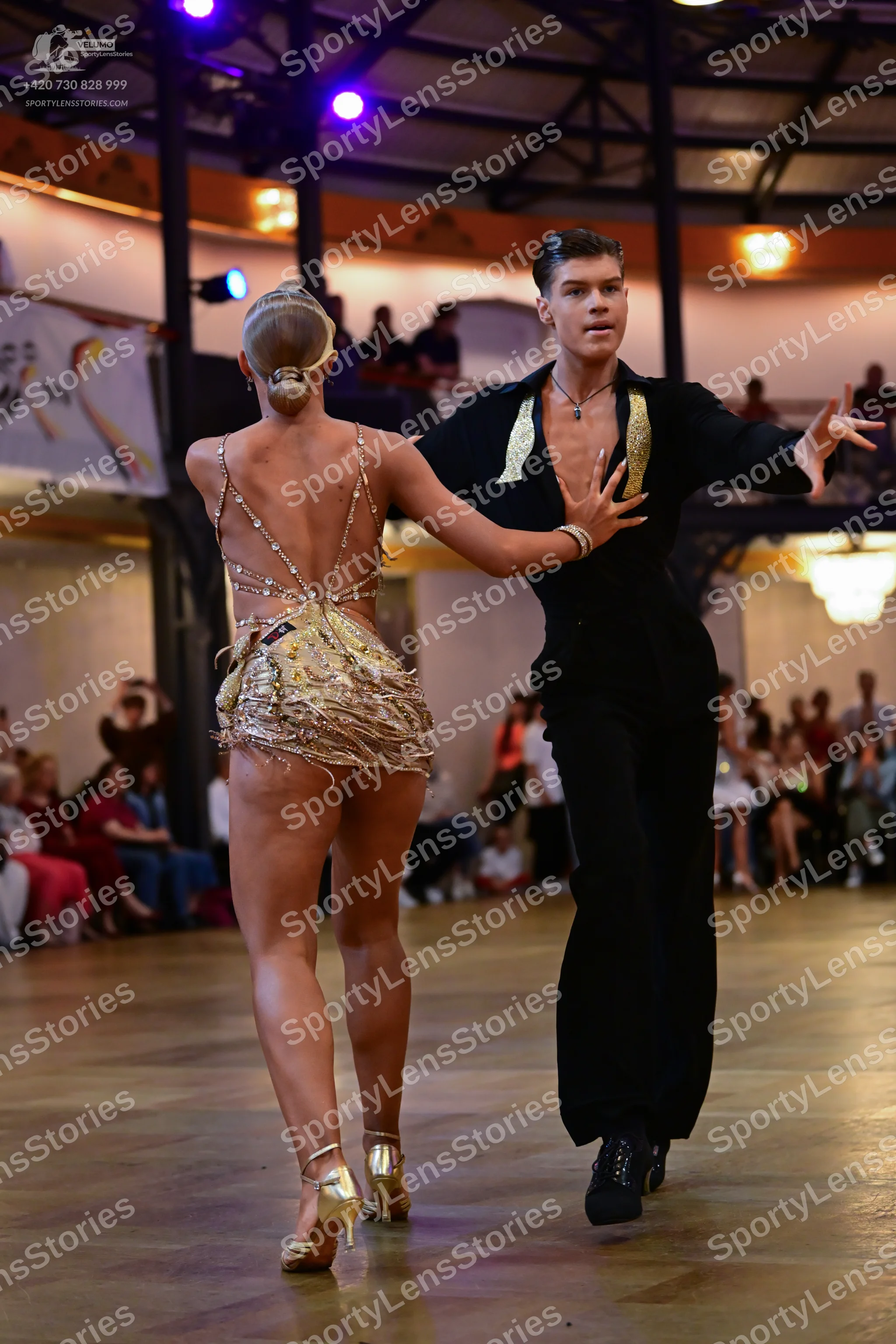 Dancesport competitor: Female dancer: gold latin dance costume with sequins and fringe, strappy back, a