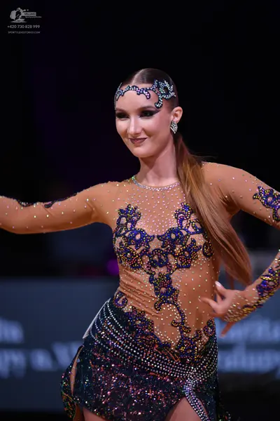 Dancesport competitor: Female dancer: nude-colored Latin dance dress with long sleeves, decorated with 