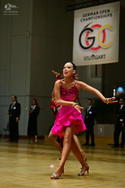 Dancesport competitor: Female dancer: short, pink, sequined Latin dress with thin straps and large pink
