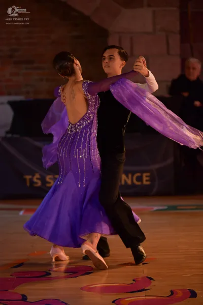 Dancesport competitor: Female dancer: purple ballroom dress with a silver sequined bodice and long, she