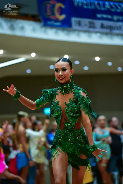 Dancesport competitor: Female dancer: emerald green latin dance dress with sequins, beads, and fringe