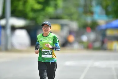 Marathon runner #5269: Runner 1: green jersey with dark long sleeves, black pants, black cap, and glass