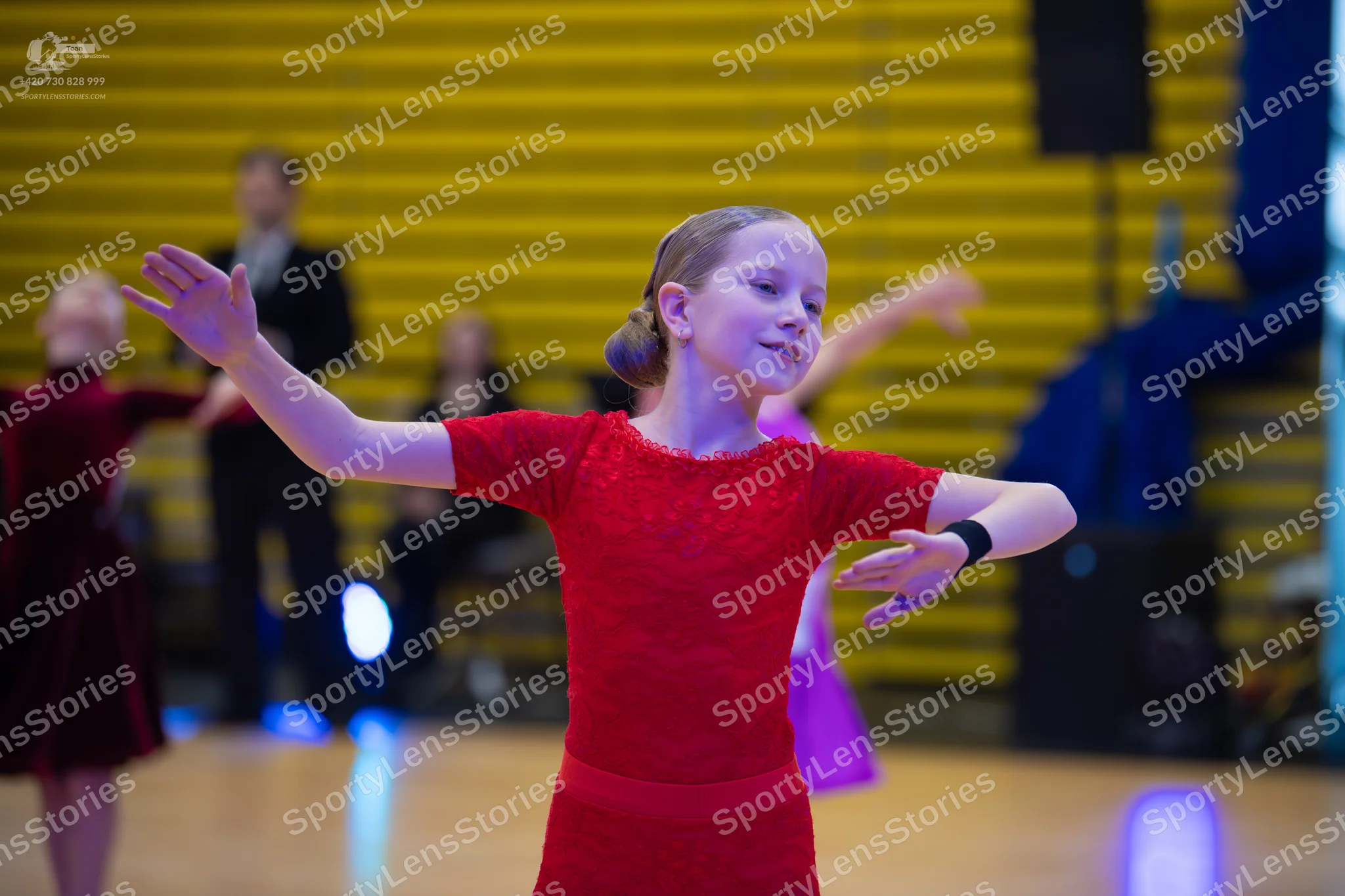 Dancesport competitor: ** Female: Red Latin dress with a high neckline and short, flared sleeves