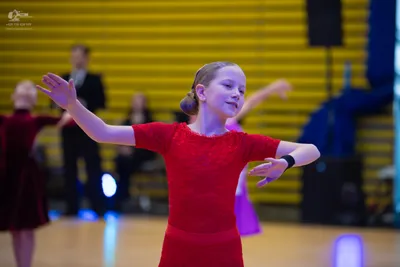 Dancesport competitor: ** Female: Red Latin dress with a high neckline and short, flared sleeves