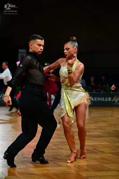 Dancesport competitor: Male dancer: black long-sleeved shirt with sheer mesh sleeves and black trousers