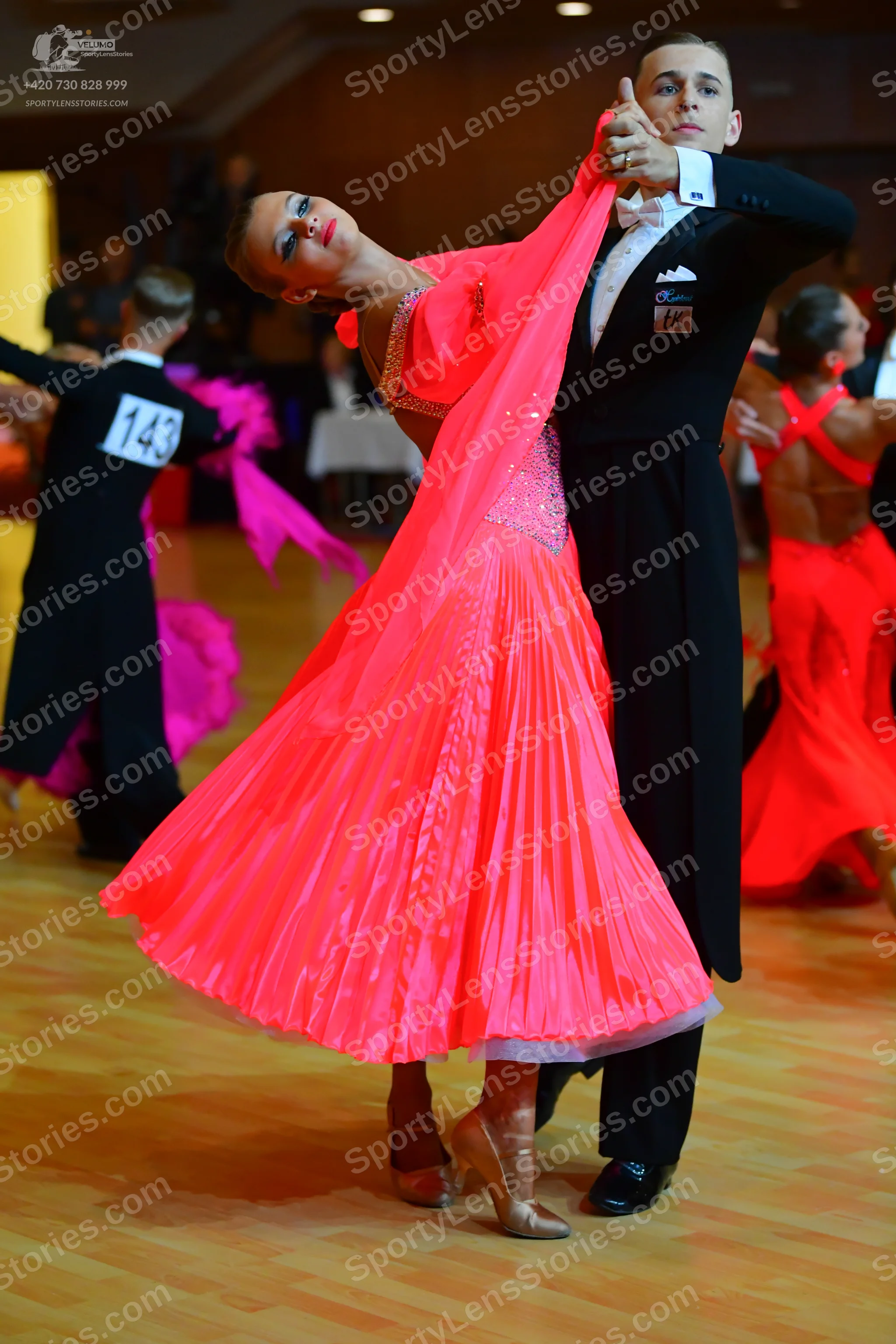 Dancesport competitor #143: Male dancer in foreground: black suit, white shirt, and black bow tie