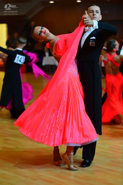 Dancesport competitor #143: Male dancer in foreground: black suit, white shirt, and black bow tie
