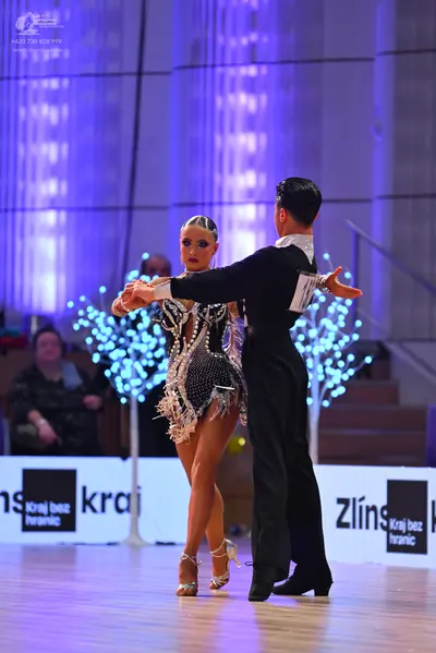 Dancesport competitor: Female dancer: short black latin dress heavily embellished with silver sequins a