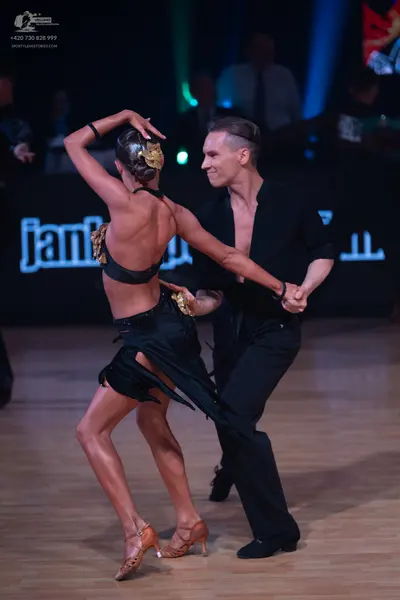 Dancesport competitor: Female dancer: black latin dress with gold sequin embellishments on the back