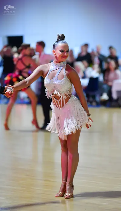 Dancesport competitor: Female dancer: white/silver latin dance dress with sequins, halter neck, cutouts