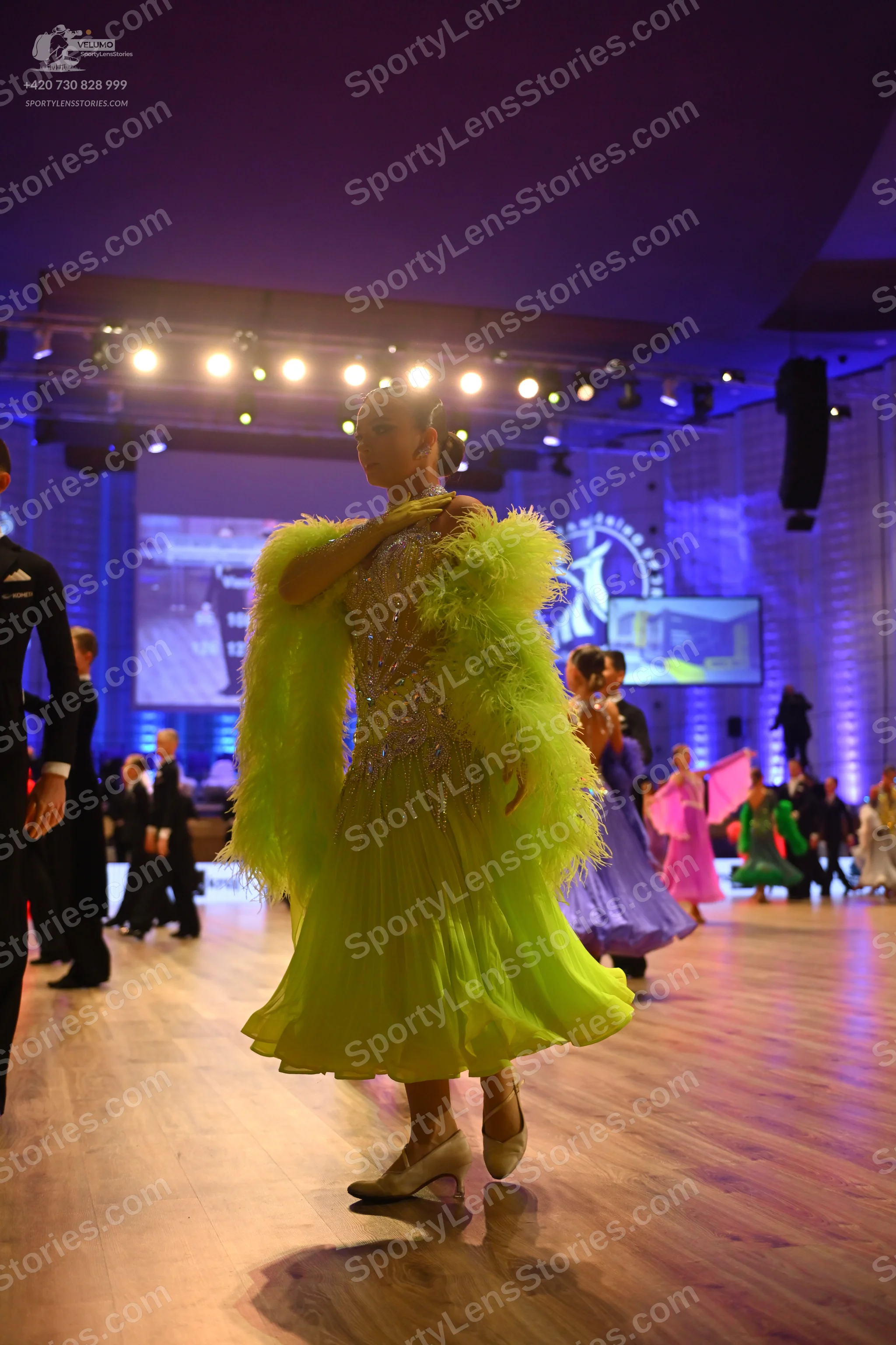 Dancesport competitor: Main female dancer: lime green Latin dress with large, fluffy feather-like textu