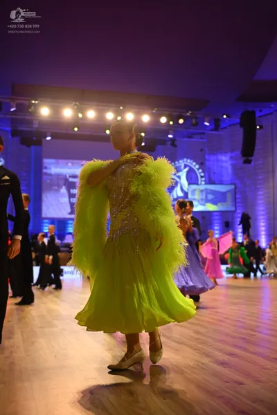 Dancesport competitor: Main female dancer: lime green Latin dress with large, fluffy feather-like textu