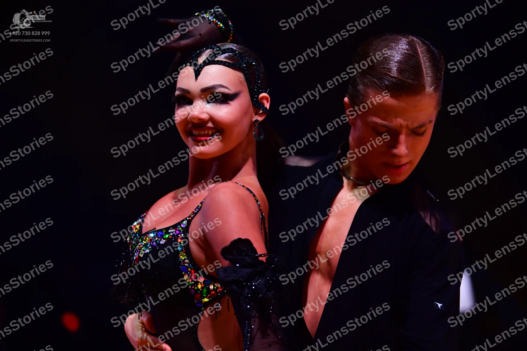 Dancesport competitor: Female dancer: black Latin dance dress adorned with multicolored sequins