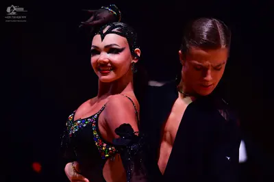 Dancesport competitor: Female dancer: black Latin dance dress adorned with multicolored sequins