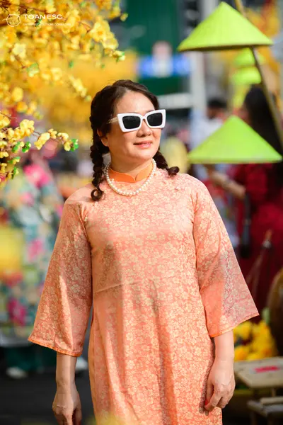 Dancesport competitor: Female dancer: peach-colored long-sleeved dress with a subtle floral pattern, ac