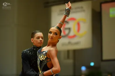 Dancesport competitor: Male dancer: black long-sleeved top with silver sequin/rhinestone embellishments