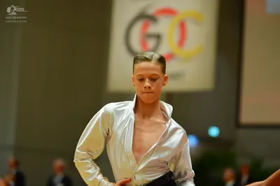 Dancesport competitor: Male dancer: light silver satin long-sleeved shirt, unbuttoned at the chest, wit