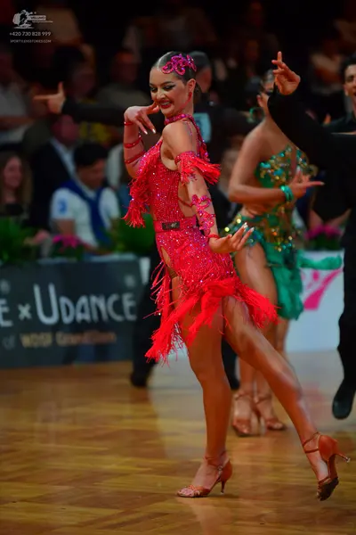 Dancesport competitor: Female dancer 1: red Latin dress with sequins and fringe
