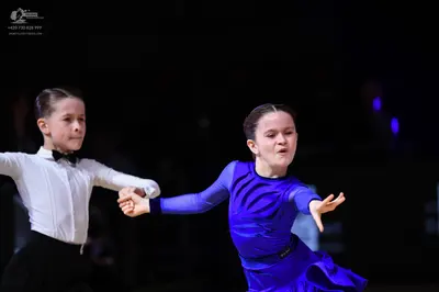 Dancesport competitor: Male dancer: white long-sleeved shirt with a black bowtie and black trousers