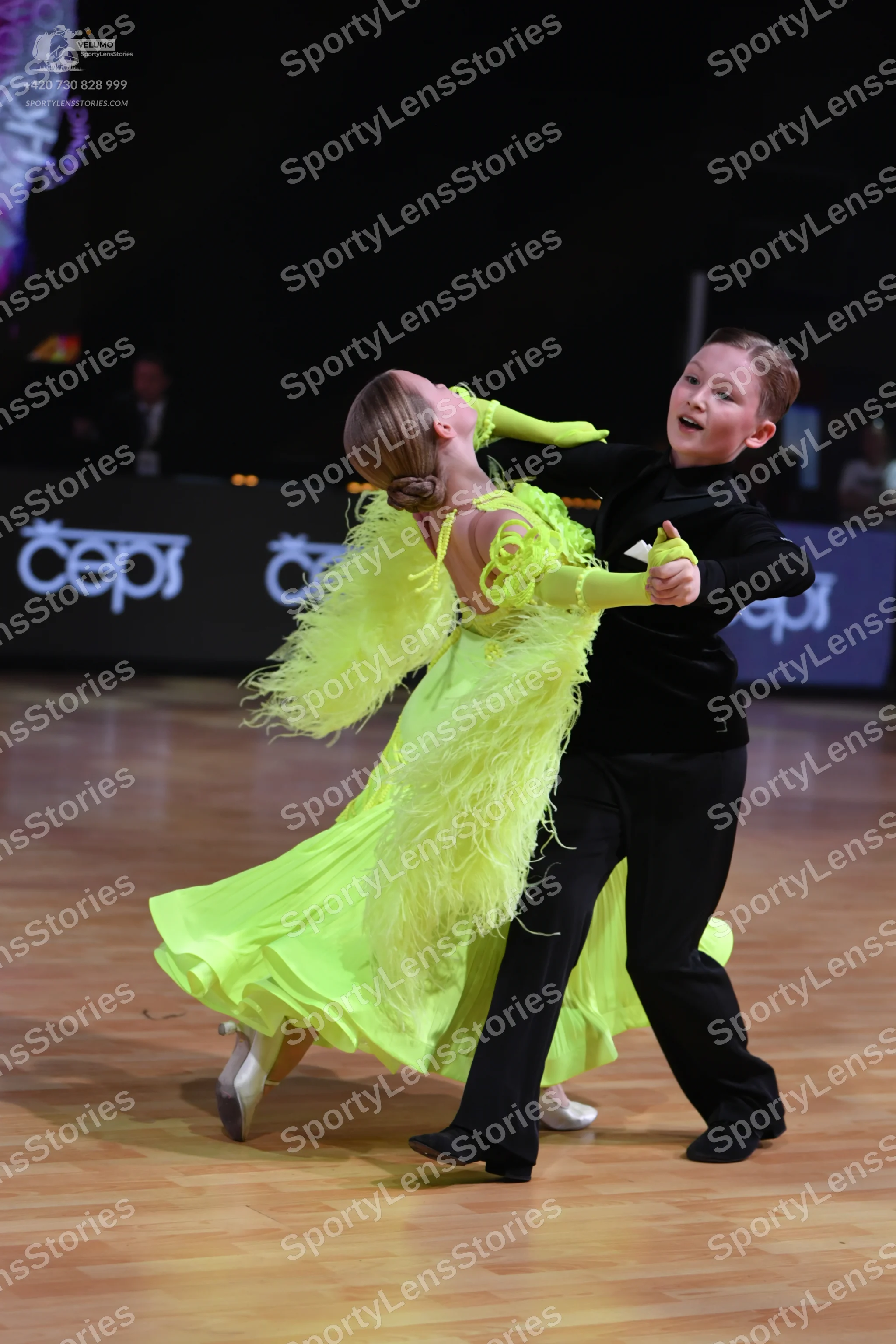 Dancesport competitor: Female dancer: bright lime green ballroom gown with long flowing fringe